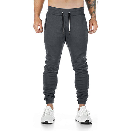 Men's drawstring track pants in dark gray worn by a model, featuring a modern fit and comfortable design.