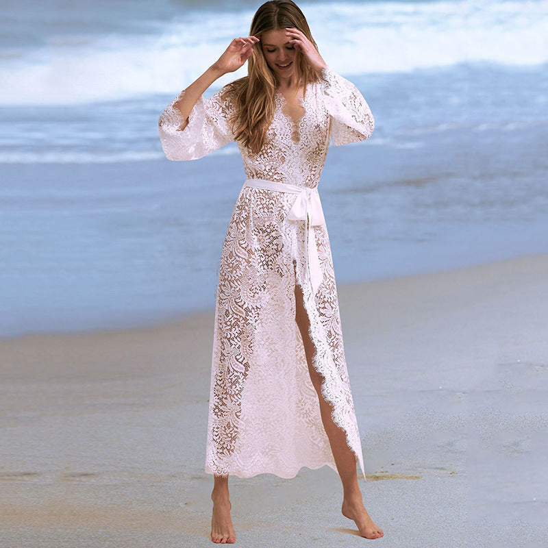 Woman in a lace beach cover-up cardigan on the beach, showcasing the Women's Lace Beach Cover-Up Cardigan by Blaze Athletic.