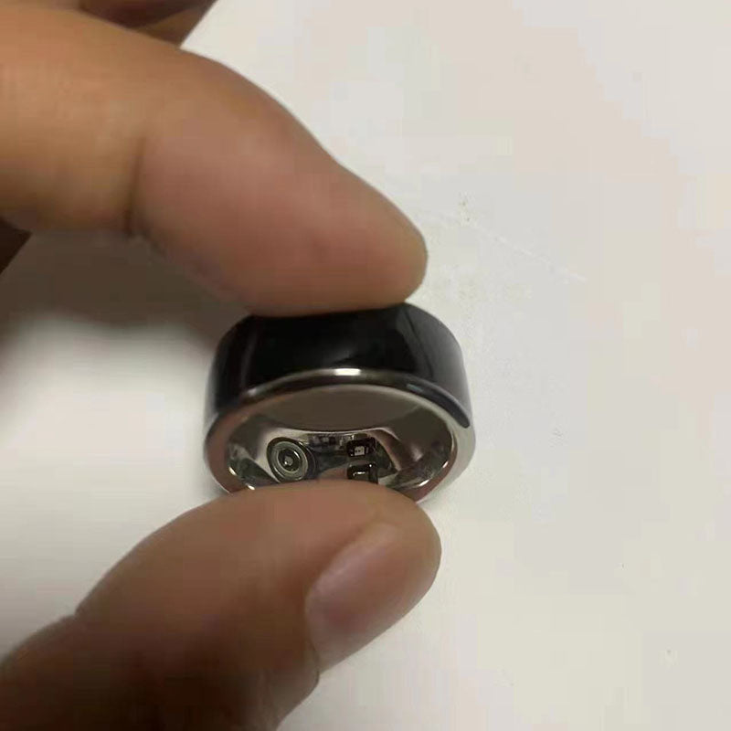 A hand holding the Smart Health Ring Bluetooth Black showcasing its sleek design and technology.